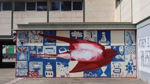 Mural a una paret de la UAB amb un ocell vermell al mig